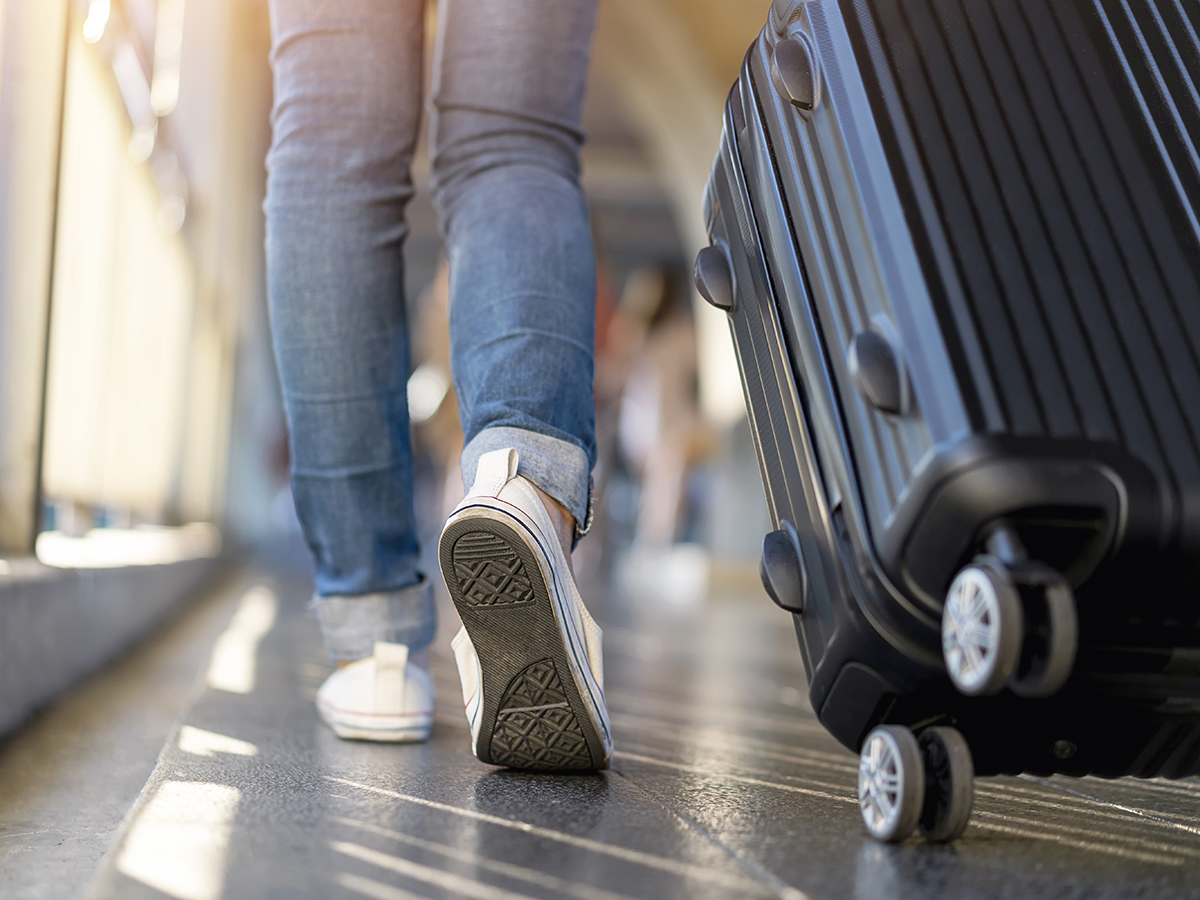 Mujer camina en el aeropuerto con su maleta