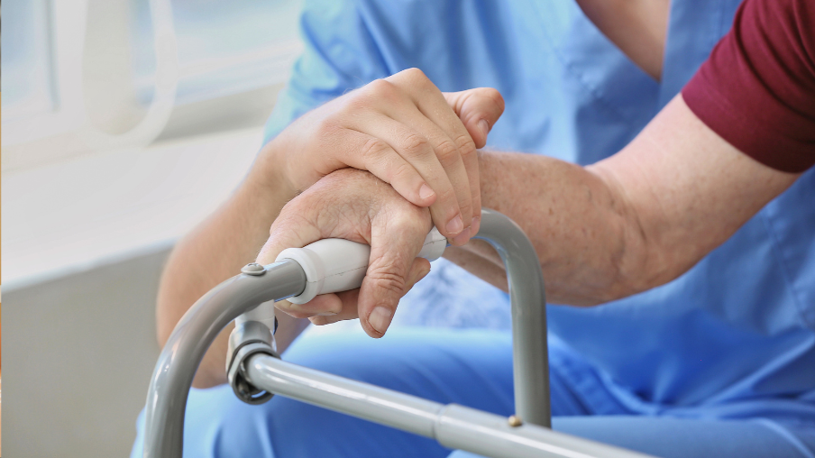 Enfermera toma la mano de un paciente anciano en la residencia